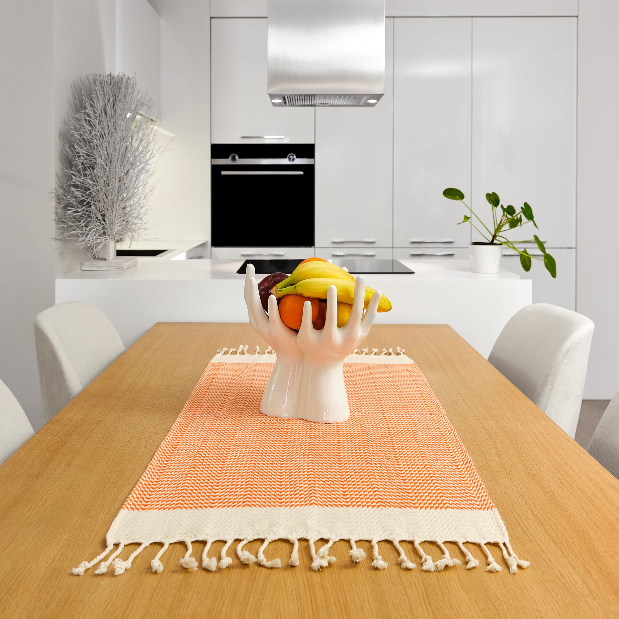 Fruit bowl on a wooden table with an orange runner in a modern kitchen